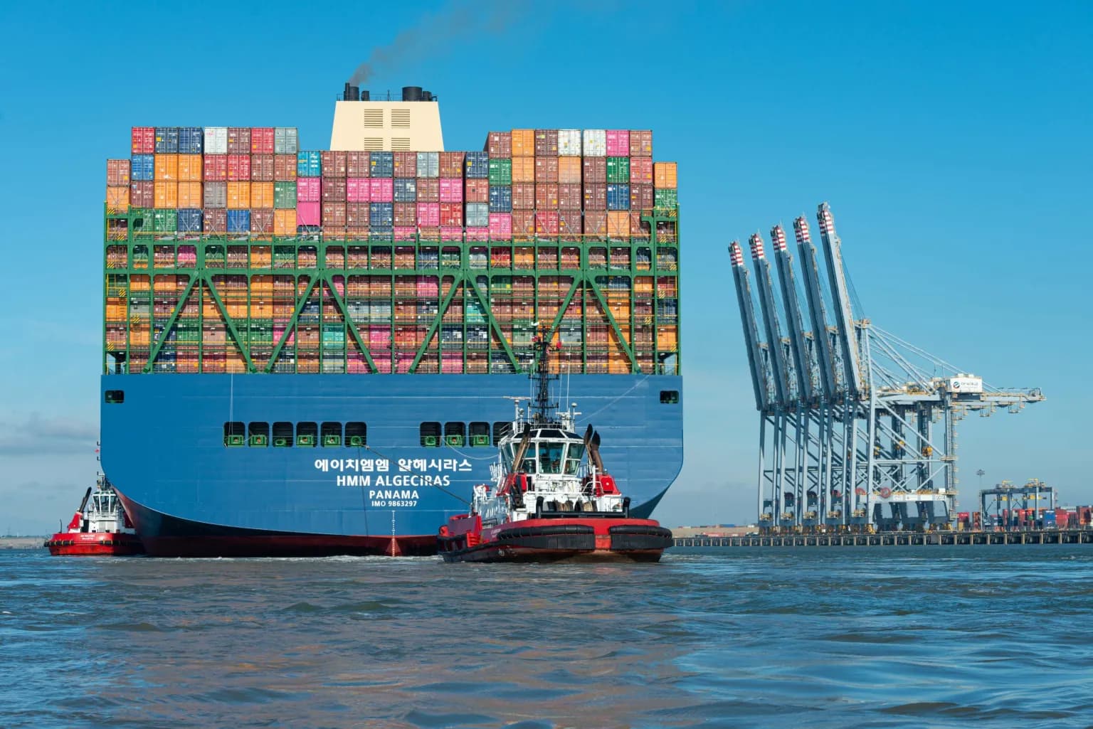 HMM Algeciras container ship loaded with thousands of colourful shipping containers entering port